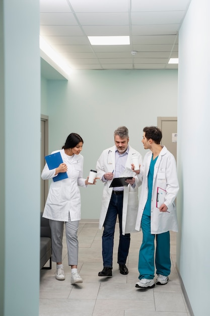 Doctores de tiro completo discutiendo en el pasillo