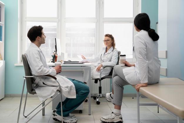 Doctores de tiro completo discutiendo en el trabajo