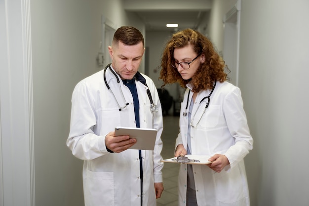 Doctores de tiro medio en el trabajo con tableta