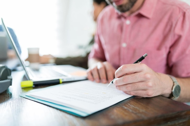 Documento de firma de empresario en el escritorio en el espacio de coworking