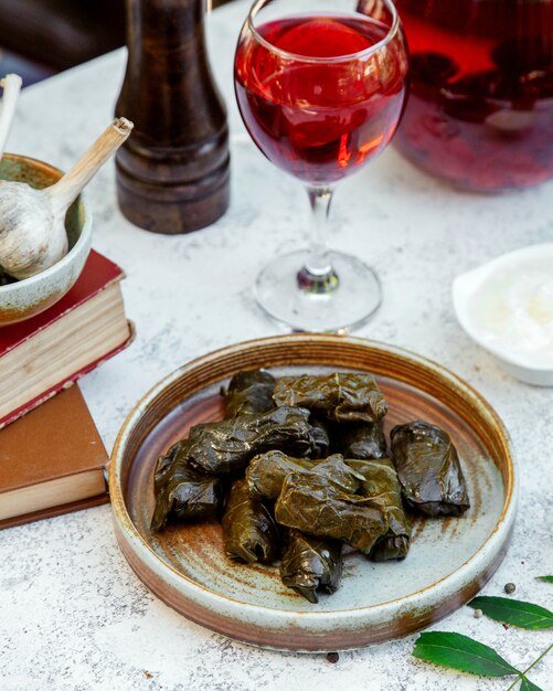 Foto gratuita dolma de hojas de uva en una cerámica y un vaso de jugo