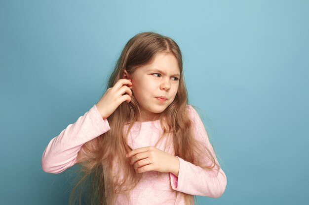 Dolor de oidos. muchacha adolescente triste con dolor de cabeza o dolor en azul. Expresiones faciales y concepto de emociones de personas.