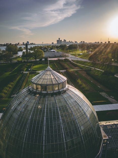 Domo en un parque rodeado de vegetación con edificios bajo la luz del sol durante el atardecer