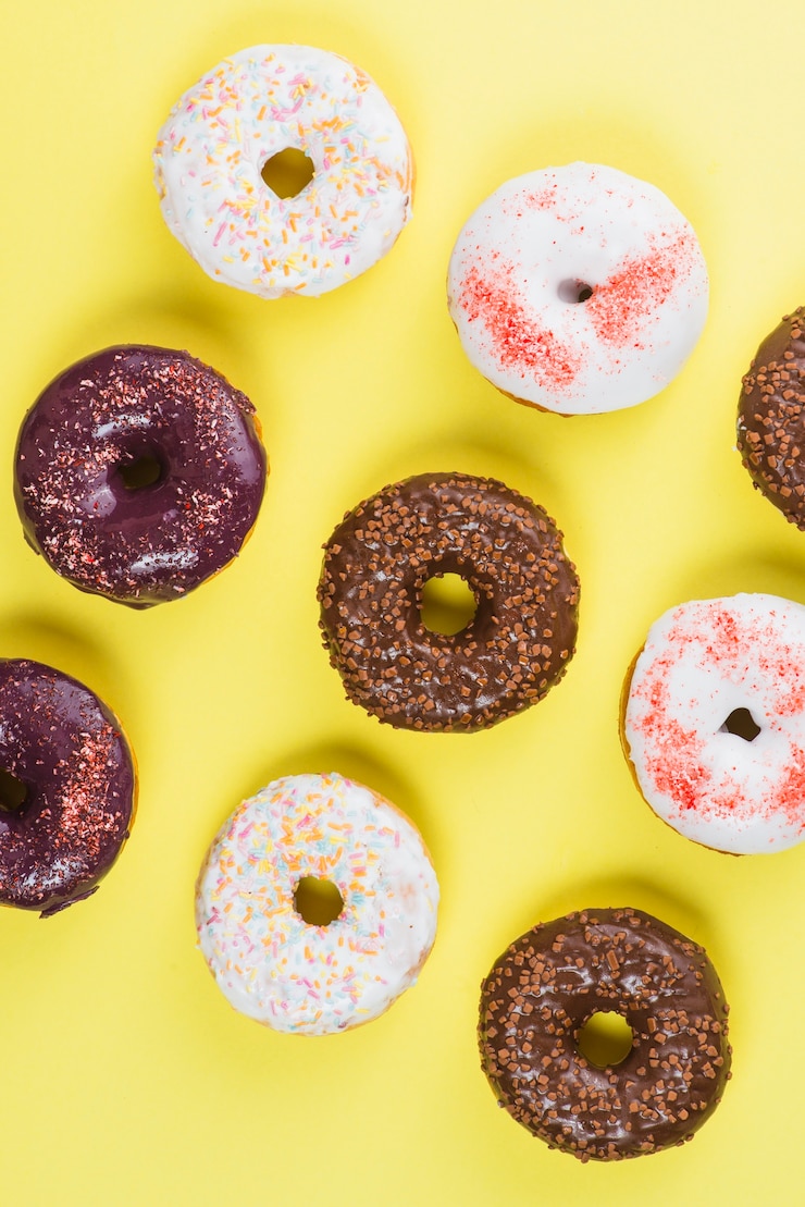 Foto gratuito donas sabrosas marrones y blancas con chispas