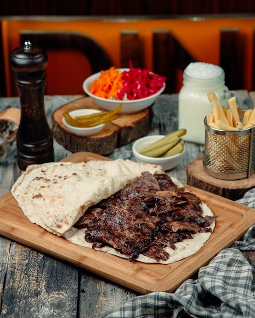 Doner de carne en lavash con encurtidos marinados y papas fritas.