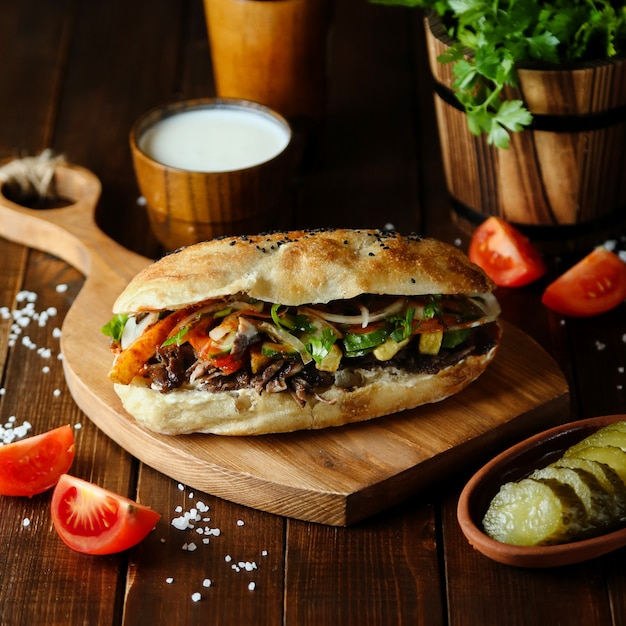 Doner de carne en el pan sobre tabla de madera