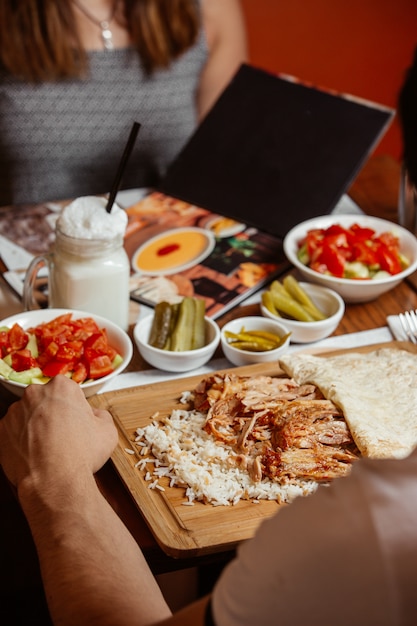 Doner kebab con arroz sobre tabla de madera