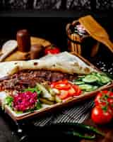 Foto gratuita doner kebab de cordero en pan plano servido con pepinillos, pepino y hierbas