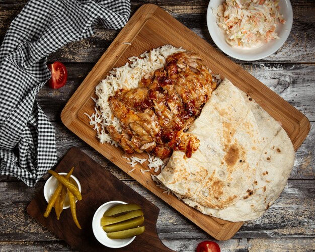 Doner de pollo frito con arroz sobre tabla de madera