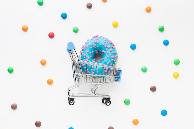 Donut en carrito de compras plano