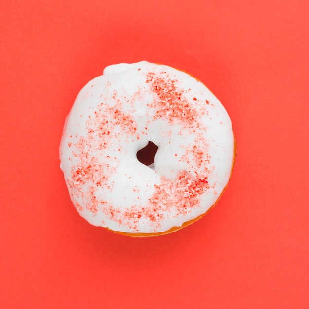 Foto gratuita donut dulce con glaseado blanco y polvo rojo