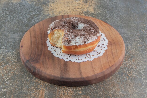 Donut mordido sobre una tabla de madera