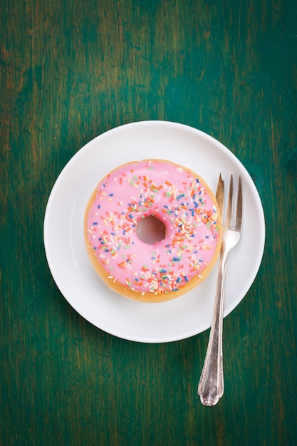 Foto gratuita donut rosa con un tenedor