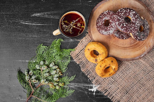 Donuts de chocolate en una bandeja de madera con té.