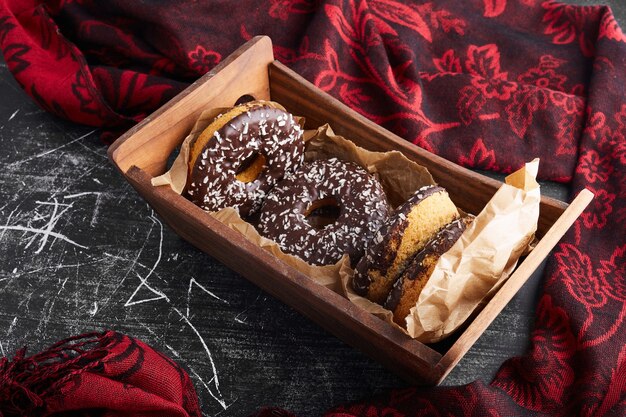 Donuts de chocolate en una bandeja de madera.