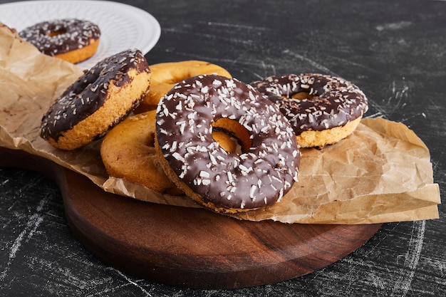 Donuts de chocolate en un plato rústico.