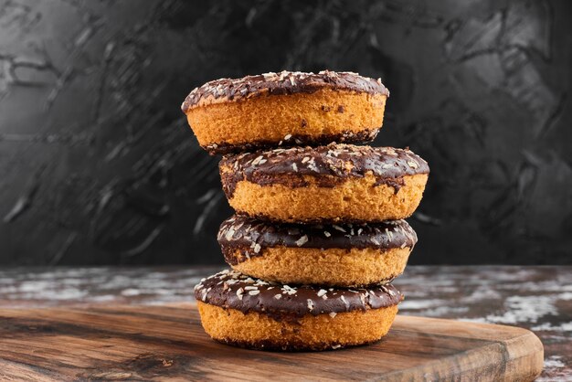 Donuts de chocolate sobre una tabla de madera.