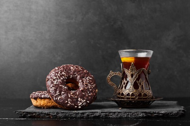 Donuts de chocolate con un vaso de té.