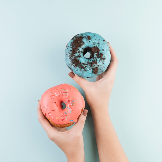 Donuts coloridos con manos