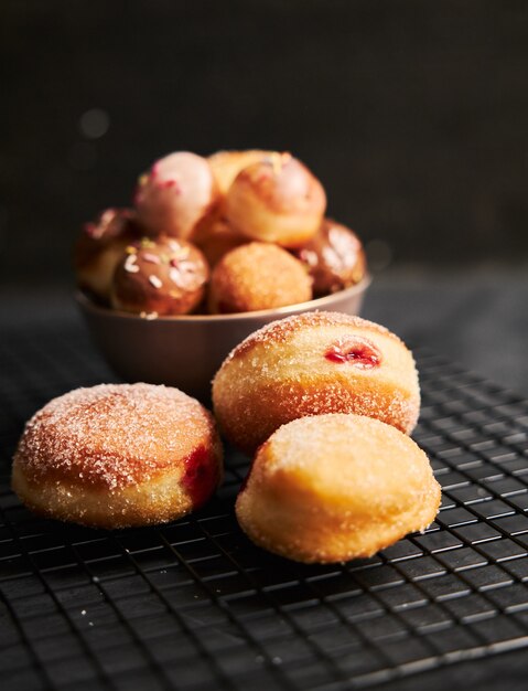 Donuts fritos con azúcar y crema sobre una mesa negra