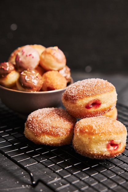 Foto gratuita donuts fritos con azúcar y crema sobre una mesa negra