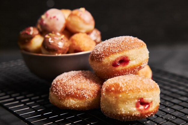 Donuts fritos con azúcar y crema sobre una mesa negra