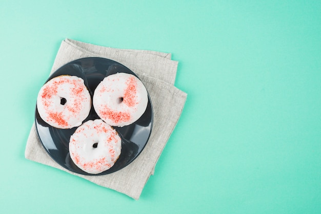 Foto gratuita donuts glaseadas con chispas en el plato