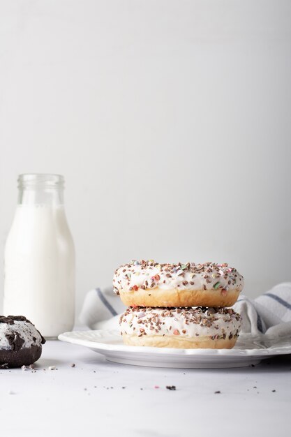 Donuts glaseados apilados con botella de leche y espacio de copia