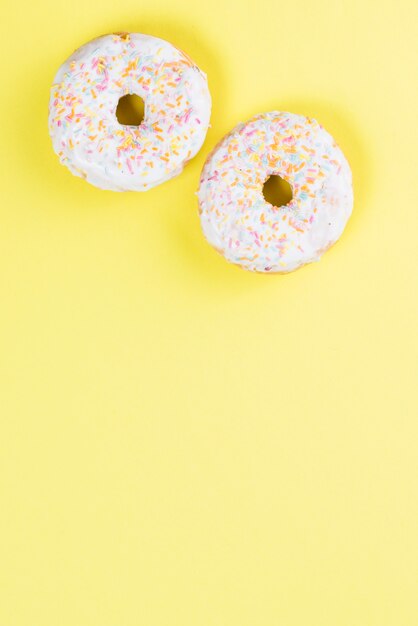 Donuts glaseados dulces decorados con chispitas de colores