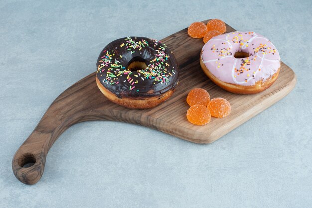 Donuts y mermeladas en una tabla de mármol.