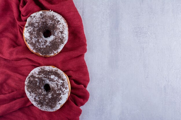 Donuts salados sobre mantel sobre fondo blanco.