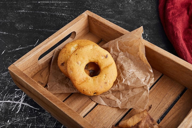 Donuts de vainilla en una bandeja de madera.