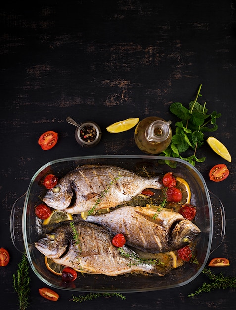 Dorado de pescado al horno con limón y hierbas en una bandeja para hornear