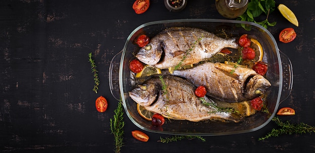 Dorado de pescado al horno con limón y hierbas en una bandeja para hornear