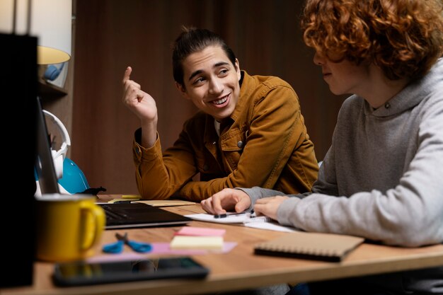 Dos adolescentes estudiando juntos en casa con una laptop