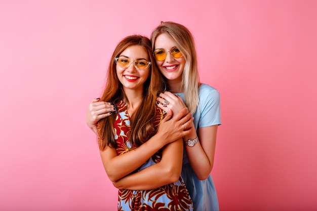 Dos adorables mujeres jóvenes felices divirtiéndose juntos