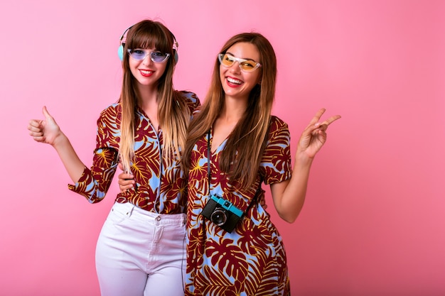 Foto gratuita dos adorables mujeres jóvenes felices divirtiéndose juntos