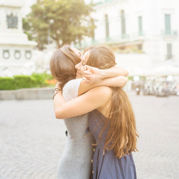 Dos amigas abrazándose al aire libre