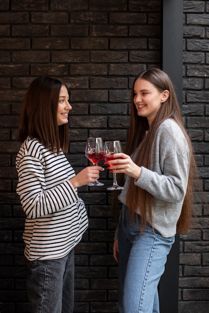 Dos amigas animando con una copa de vino