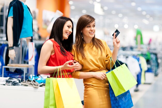 Dos amigas con bolsas de la compra.