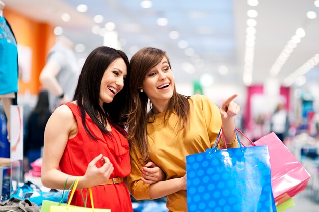 Dos amigas con bolsas de la compra.