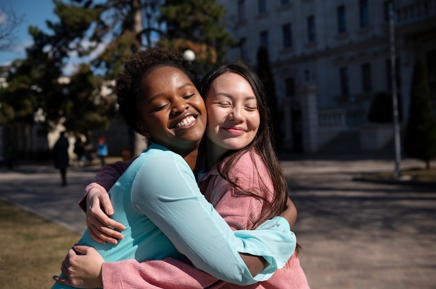 Dos amigas celebrando el levantamiento de las restricciones de mascarillas al aire libre