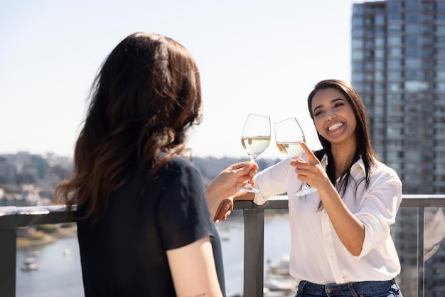 Dos amigas conversando y disfrutando de un vino en una terraza en la azotea