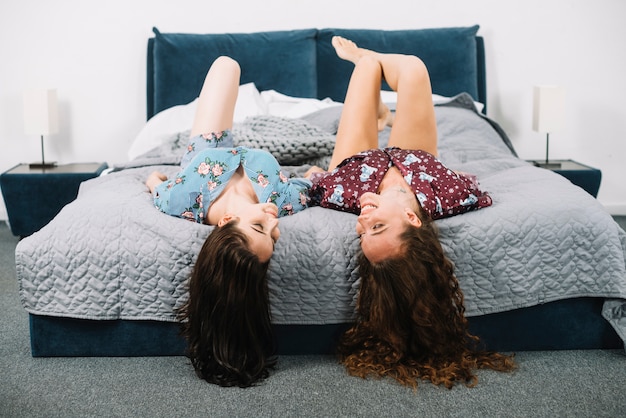 Dos amigas descansando en la cama en casa