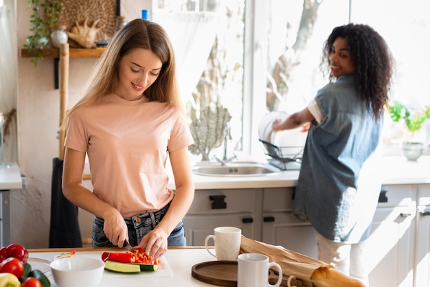 Foto gratuita dos amigas divirtiéndose mientras cocinan juntos