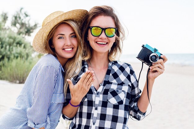 Dos amigas felices divirtiéndose en la playa