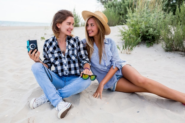 Dos amigas felices divirtiéndose en la playa