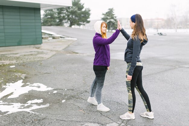 Dos amigas en invierno dando alta cinco