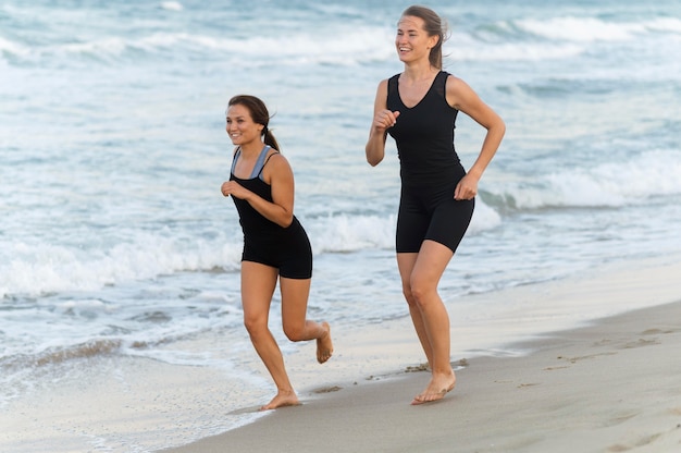Dos amigas, jogging, juntos, en la playa