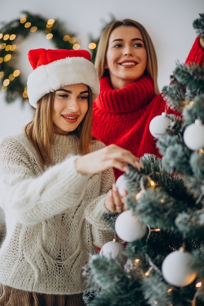 Dos amigas junto al árbol de navidad